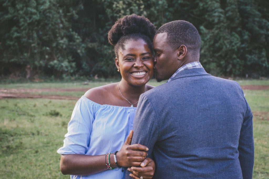 man-kissing-left-cheek-of-smiling-woman-1667847-min