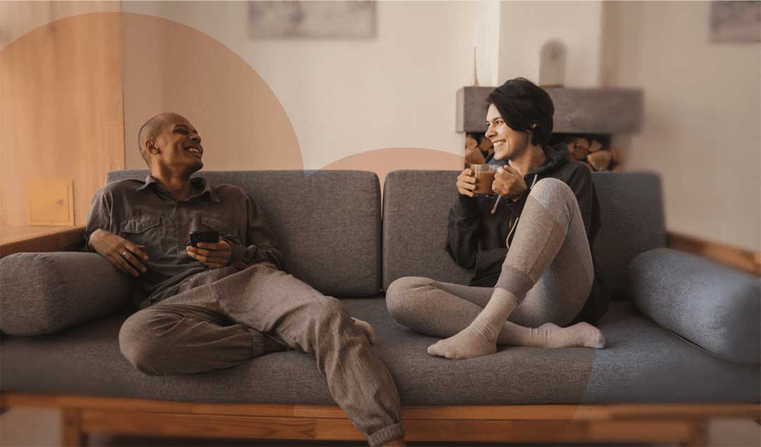 couple laughs together on couch