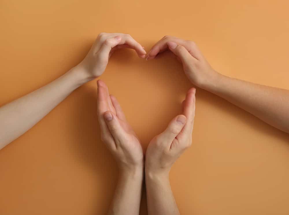 Consensual non-monogamy Human hands making heart on color background. Polyamory concept Human hands for consensual nonmonogamy